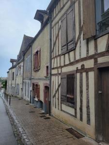 an old building on a cobblestone street at Sous murs, petite maison de ville au charme authentique in Auxerre