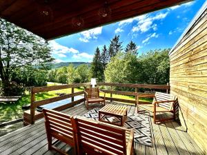 a wooden deck with two chairs and a table at Chaly in Stoumont