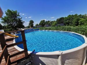 a swimming pool with a chair around it at Bachus in Chmielno