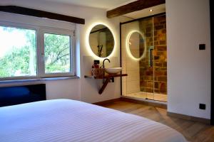 a bedroom with a bed and a sink and mirror at Chaly in Stoumont