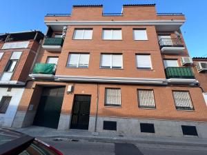 a tall brick building with a lot of windows at Atico in Tomelloso