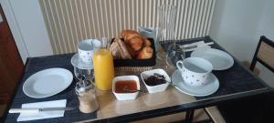 a table topped with plates and a basket of bread at Chambre,petit déjeuner inclus in Chantonnay
