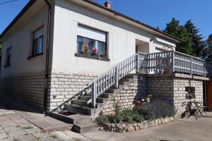 a house with a staircase with flowers in a window at Tündér Villa in Balatonfüred