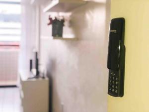 ein schwarzes Telefon an der Seite eines Kühlschranks in der Unterkunft RF-86: Apê completo e aconchegante na Ponta Verde in Maceió