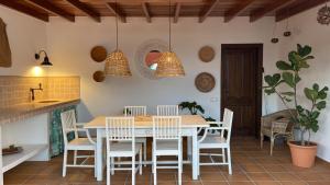 a dining room with a white table and chairs at Casa Tegue in Nazaret