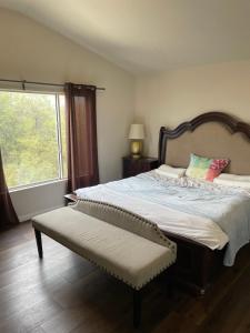 a bedroom with a bed with a bench and a window at Master Bedroom inside a Gorgeous Home in a Beautiful Neighborhood in Las Vegas