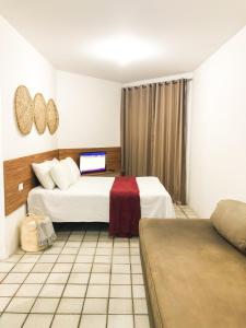 a hotel room with two beds and a laptop at T-36: Flat charmoso a Beira mar da Pajuçara in Maceió