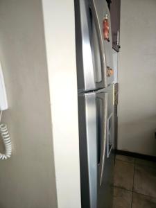 un frigorifero in acciaio inossidabile nell'angolo di una cucina di hostal Yeti Inn a Cuenca