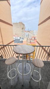a table and two stools on a balcony at Aly Home in Castellón de la Plana