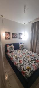 a bedroom with a bed with a floral comforter at Lecomte studio in Oissel