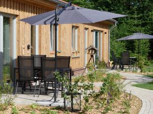 KirchwahlingenAlpaka-Lodge的庭院内桌椅和遮阳伞