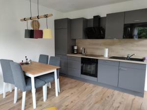 a kitchen with a wooden table and blue chairs at Alpaka-Lodge in Kirchwahlingen