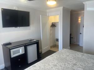 a bedroom with a bed and a flat screen tv on the wall at El Rancho Motel in Williams
