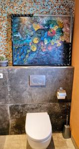 a bathroom with a toilet and a painting on the wall at Taunusblick in Bad Camberg +9 photos
