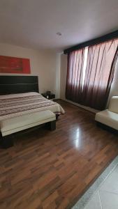 a bedroom with a bed and a wooden floor at Hotel Paraiso in Mexico City