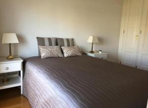 una camera da letto con un grande letto e due comodini di Guia Cascais Room Suite Opportunity a Cascais