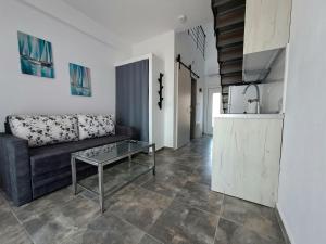 a living room with a couch and a table at Apollon Luxury Rooms in Nea Vrasna