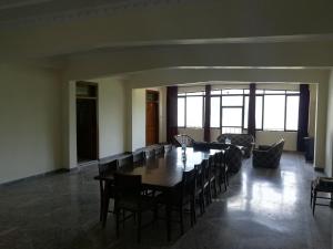 a dining room with a long table and chairs at Last Resort, Sajjan Gali in Nathia Gali