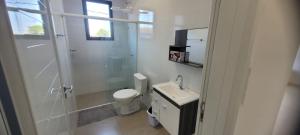 um banheiro com chuveiro, vaso sanitário e pia em Apartamento Novo Próximo a pontos turisticos em Foz do Iguaçu mais 16 fotografias