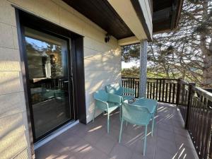 Un porche con tres sillas y una ventana en una casa. en geschmackvolle Wohnung in Katsdorf, modern und bequem, en Katsdorf