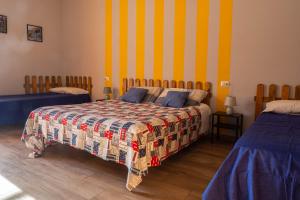 a bedroom with two beds and a yellow and blue stripes at I Girasoli Holiday Home in Pompei