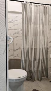 a bathroom with a toilet and a shower curtain at Agape Speranta 96 in Piteşti