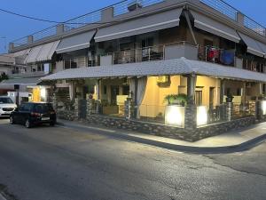 un coche aparcado delante de un edificio en Avra Comfort Rooms - Family, en Nea Potidaea