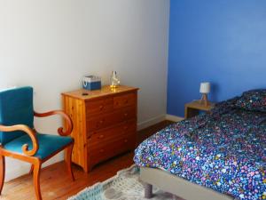 a bedroom with a bed and a chair and a dresser at Kerispern-Ti Mestr in Trégunc