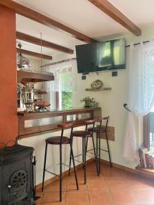 a kitchen with three bar stools and a stove at Sielanka Kretowiny in Kretowiny +56 photos