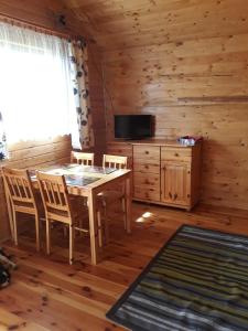 a dining room with a table and chairs in a cabin at Drewniane Domki Pod Sokołem in Sterławki Wielkie