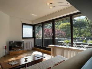 a living room with a couch and a tv at Große Loft- Wohnung Glück im Grünen in Rösrath