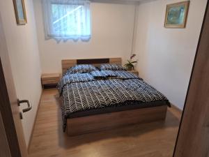 a bedroom with a bed with a comforter and a window at APARTMENT BELkA in Jesenice