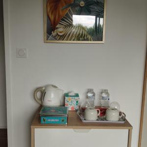 a shelf with tea pots and water bottles on it at chez Sandrine in Miniac-Morvan +22 photos