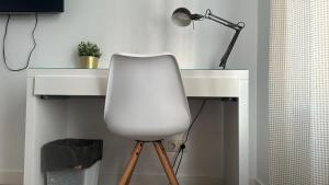 a white desk with a lamp and a white chair at Habitaciones plaza payor in Madrid