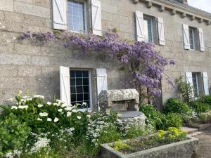 a building with purple flowers on the side of it at Kerispern-Ti Mestr in Trégunc