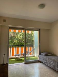 a bedroom with a bed and a sliding glass door at GuestRoom - Chambre d'hôte in Le Cannet