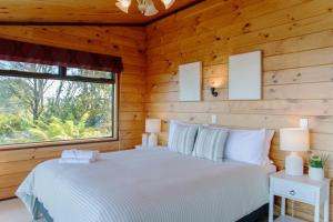 a bedroom with a bed in a log cabin at Lakeside Haven in Rotorua +37 photos