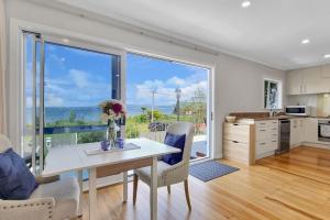 une cuisine avec une table et des chaises ainsi qu'une grande fenêtre dans l'établissement Lake of Tranquility, à Rotorua