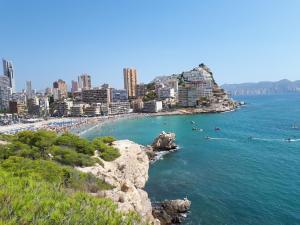 a view of a beach with people swimming in the water at Fantástico apartamento playa in Cala de Finestrat