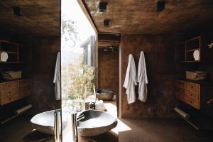 a bathroom with two sinks and a large window at Bruma Wine Resort in Valle de Guadalupe