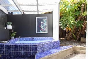 eine blaue geflieste Wanne mitten in einem Innenhof in der Unterkunft Hinemoa Haven in Rotorua
