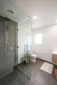 ein Badezimmer mit Glasdusche und Toilette in der Unterkunft Clareview Cottage in Rotorua