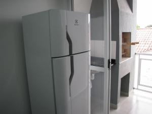 a white refrigerator in a kitchen next to a window at RCM Vilas - Apartamento n 12 in Joinville