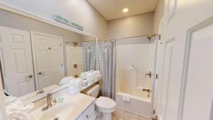 a bathroom with a sink and a toilet and a mirror at 2 Bdrm Lakeside Villa Scenic View With Amenities in Pawleys Island +20 photos