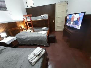 a bedroom with two bunk beds and a flat screen tv at C'Aroma de Mujer in San Salvador de Jujuy