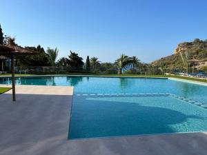 a large swimming pool with blue water at Modern apartment sea view with private jacuzzi in Villajoyosa