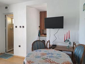 a dining room with a table and a tv on a wall at Villa Anastasia in Sinemorets +9 photos