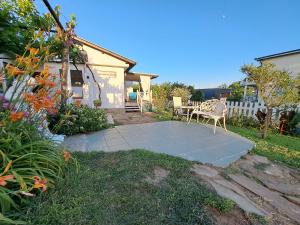 a patio with a table and a chair in a yard at Villa Anastasia in Sinemorets