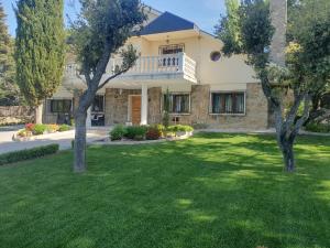 a house with a green yard with trees at Villa Monika in Alpedrete