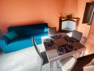 a dining room with a blue couch and a table at La casa storica in Santu Lussurgiu
